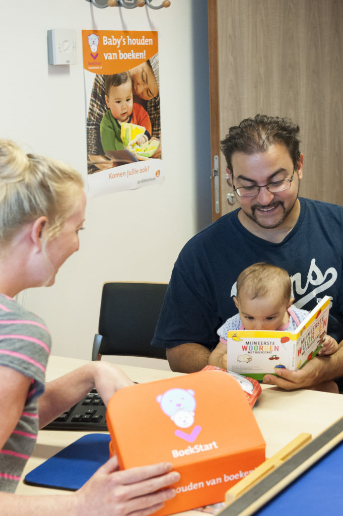 Vader met baby op consultatiebureau, BoekStartkoffer wordt uitgereikt