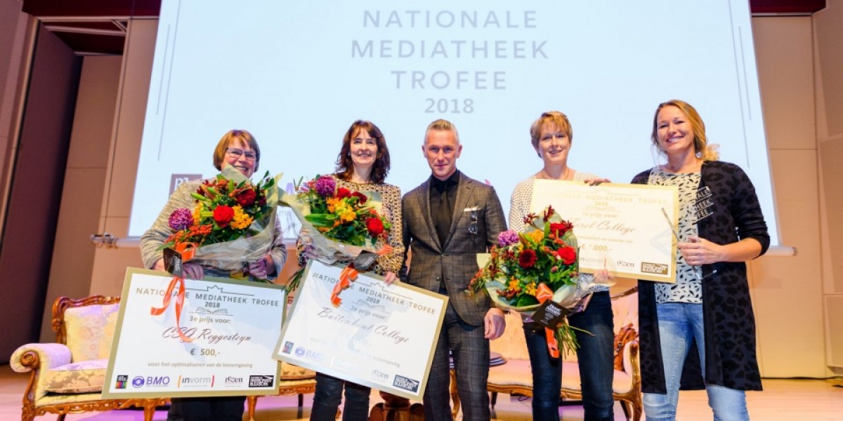 De vier winnaressen op het podium met bloemen en oorkondes.