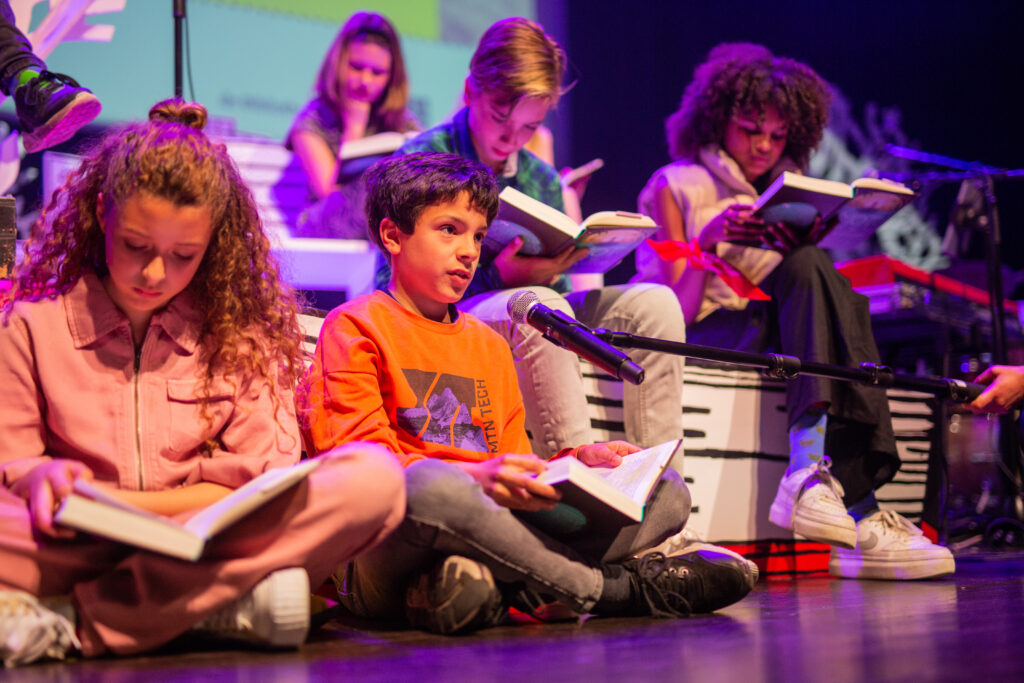 Kinderen lezen voor op het podium.