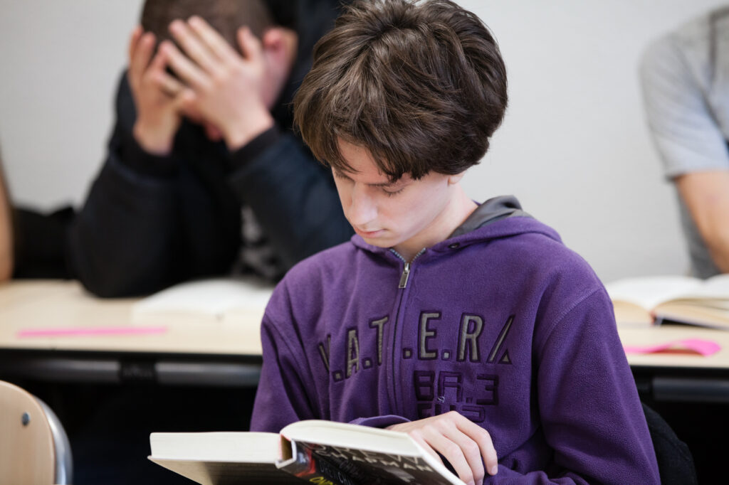 Jongen leest in de klas