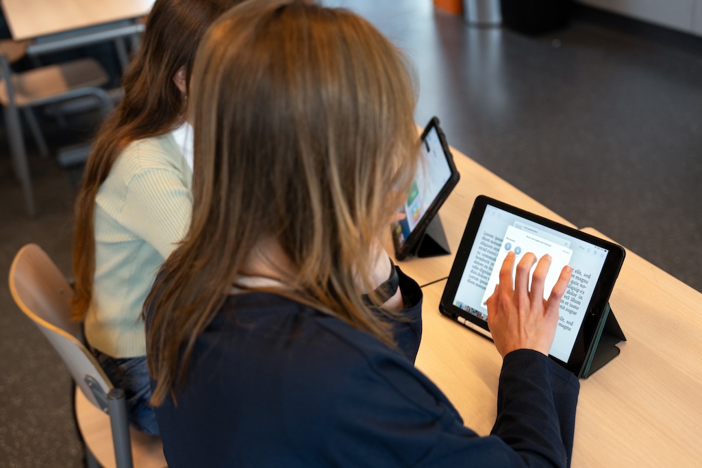 Leerling leest op school vanaf tablet.