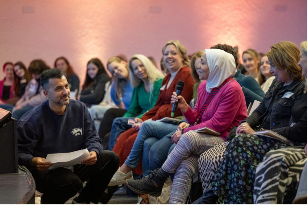 Presentator stelt een vraag aan het publiek.