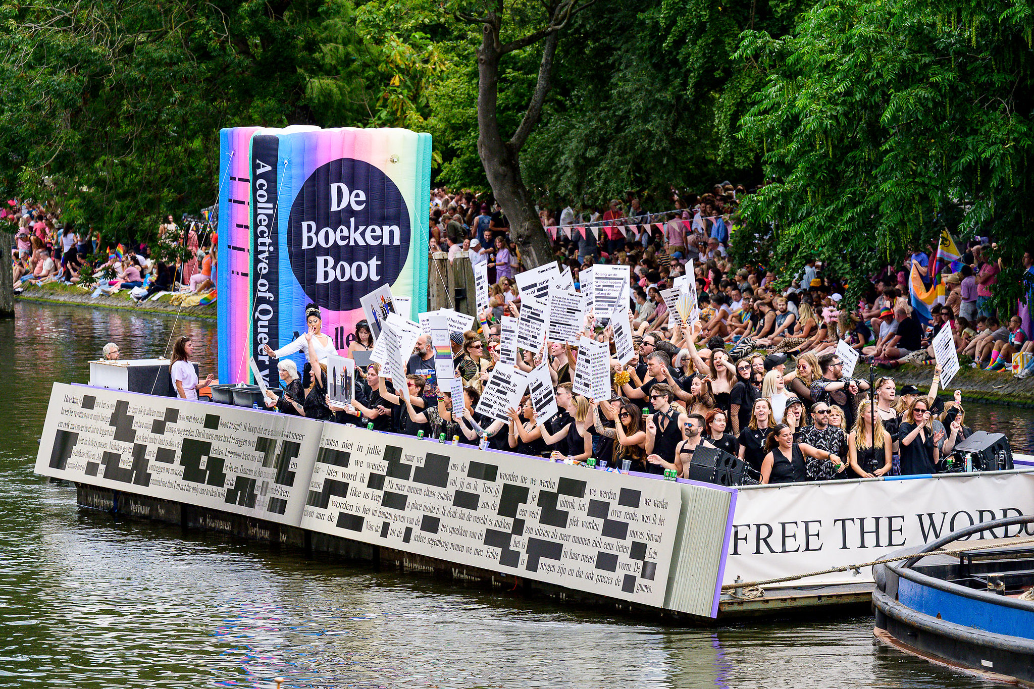 De Boekenboot met opvarenden die hun protestborden omhoog houden